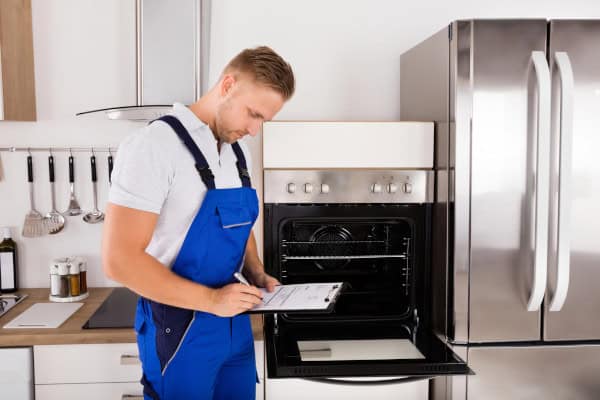 Appliane Tech Doing Maintenance On Stove